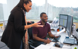 two employees working together on a computer