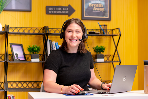 CC-2 woman wearing a headset smiling at camera
