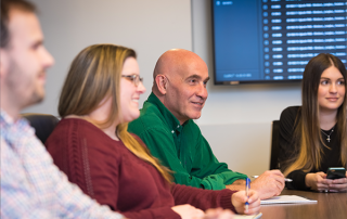 four employees working at a conference table