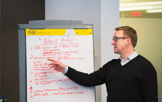 man pointing at a white board