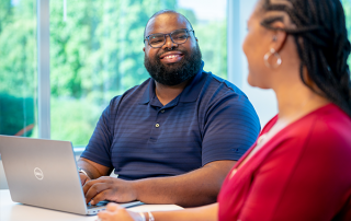 man and woman sitting at table working together