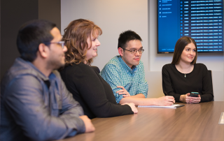 four people sitting at conference table