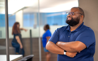 man with arms crossed smiling